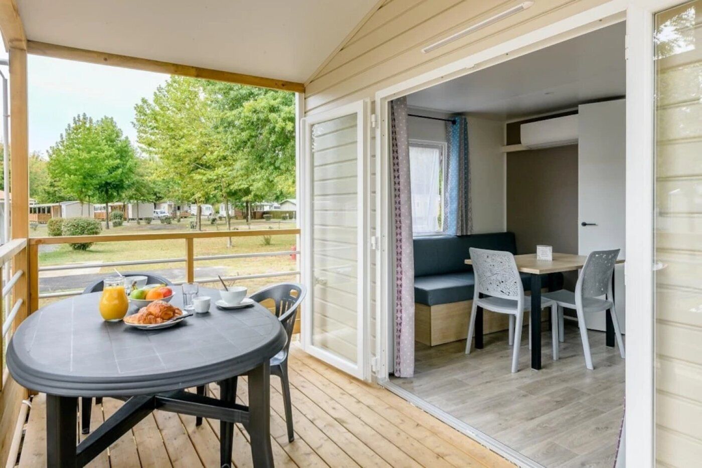 Een balkon met een ontbijttafel, een bank en een raam met gordijnen.