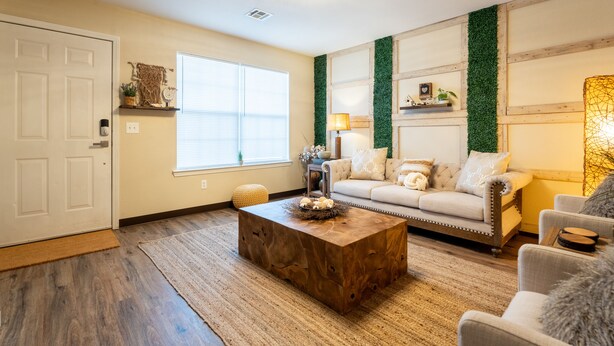 A living room with a wooden coffee table, a sofa, and a lamp. - Townhome with a peaceful, soothing vibe, featuring KING and QUEEN size beds (Springdale)