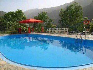 Relax by the pool surrounded by lush greenery and breathtaking mountain views.