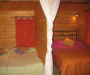 Cozy cabin with a bed, wooden walls, and a window.