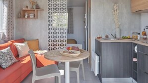 A modern living space with a sofa, dining table, and kitchen area.