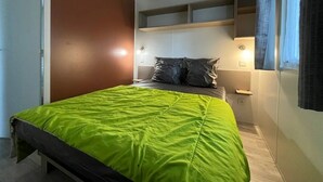 Une chambre à coucher avec un lit, des tables de chevet et des étagères intégrées.