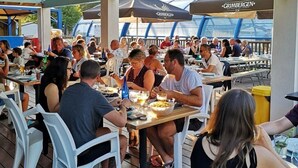 Un espacio de comedor al aire libre con mesas y sillas bajo techo.