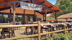 Un bar-restaurant doté d’une terrasse et d’une plateforme en bois.