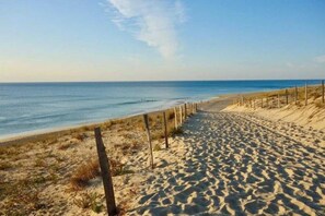 A sandy beach with a wooden fence and a clear view of the ocean. - ZEcamping 4 étoiles piscine couverte pet friendly club enfant tente TV (Azur)