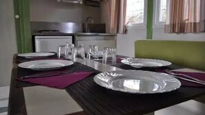 Una mesa de comedor dispuesta con platos, vasos y cubiertos.