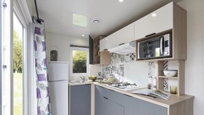 A compact kitchen with a built-in microwave, a gas stove, and a sink.