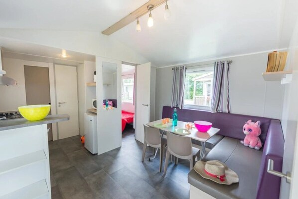 A compact kitchen with a dining area, a small table, and a sofa.