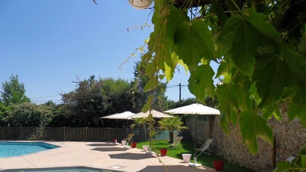 A swimming pool with a tiled deck, surrounded by lounge chairs and umbrellas. - ZEcamping 3 étoiles piscine pet friendly bien-être locatif TV 22m2 4 pers (Urt)