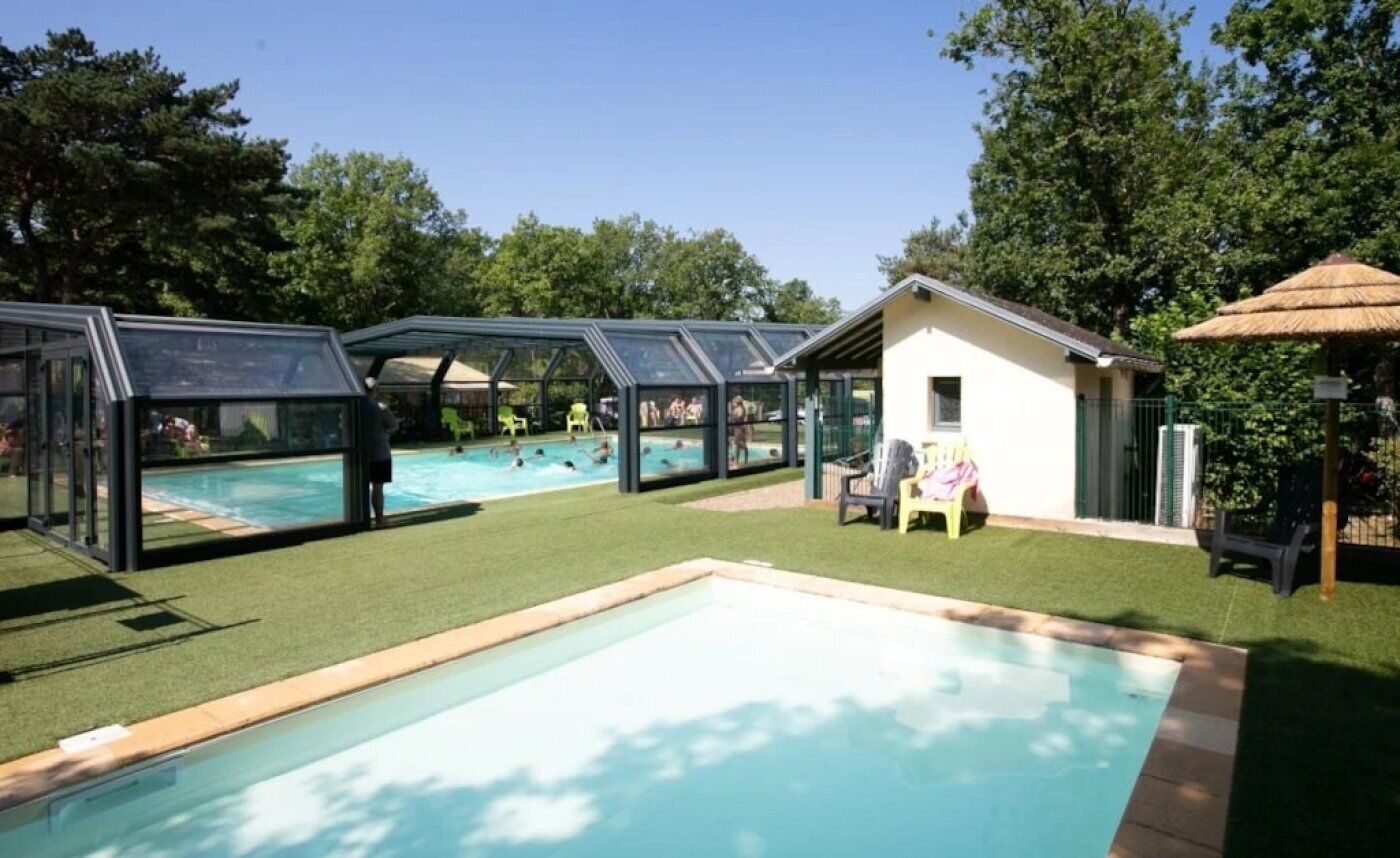 Un'area piscina con sezioni vetrate e un piccolo edificio.