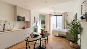 Eine moderne Küche mit Esstisch, einem Bett und einem großen Fenster.