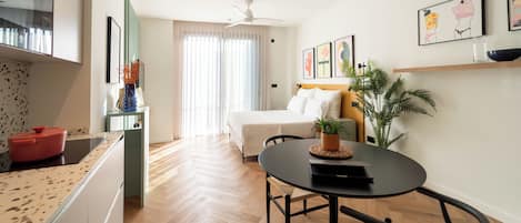 Una habitación de hotel moderna con cocina, comedor y cama.