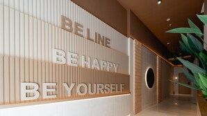 A modern interior with a motivational wall displaying the words "BELINE BE HAPPY BE YOURSELF". - NIU Line (Villajoyosa)