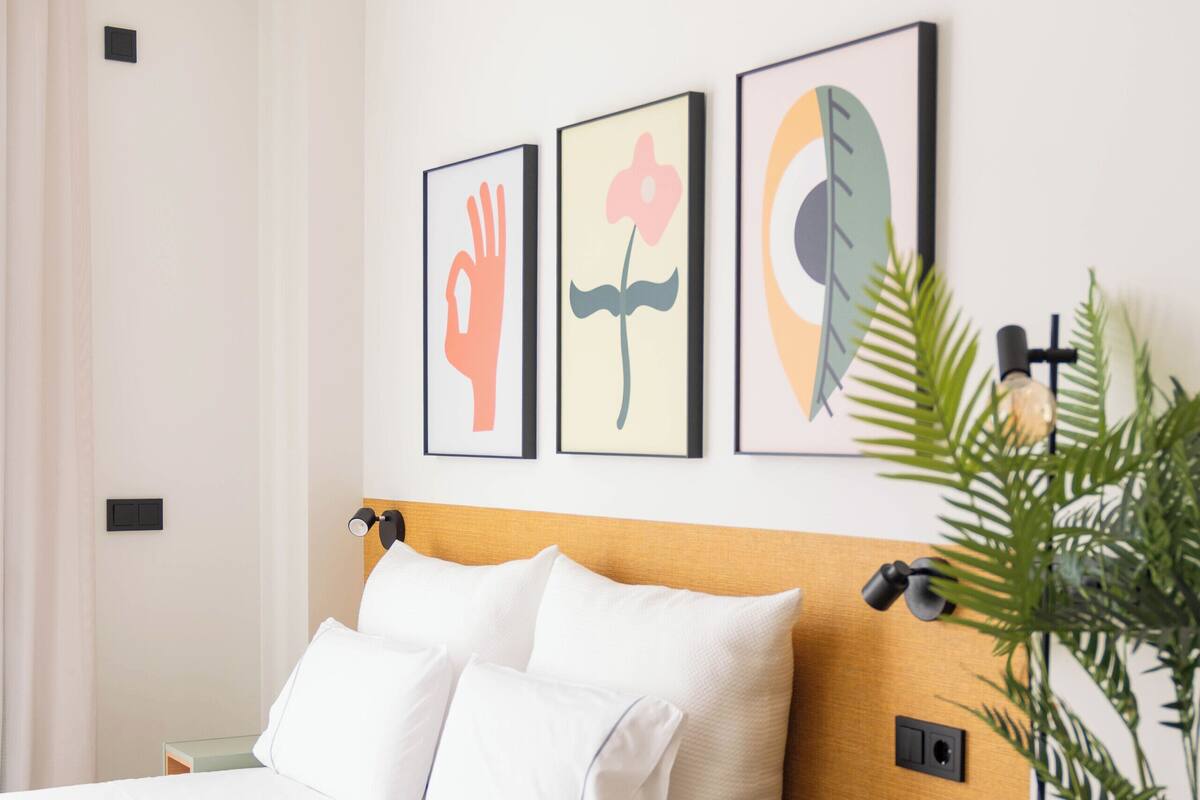 A neatly arranged bedroom with a bed, bedside table, and a small cabinet.