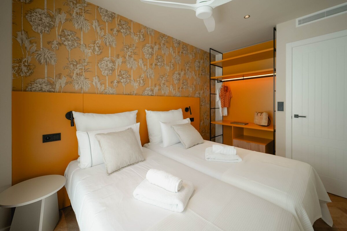 Une chambre d’hôtel avec un grand lit, une table de chevet, une armoire et un espace douche.