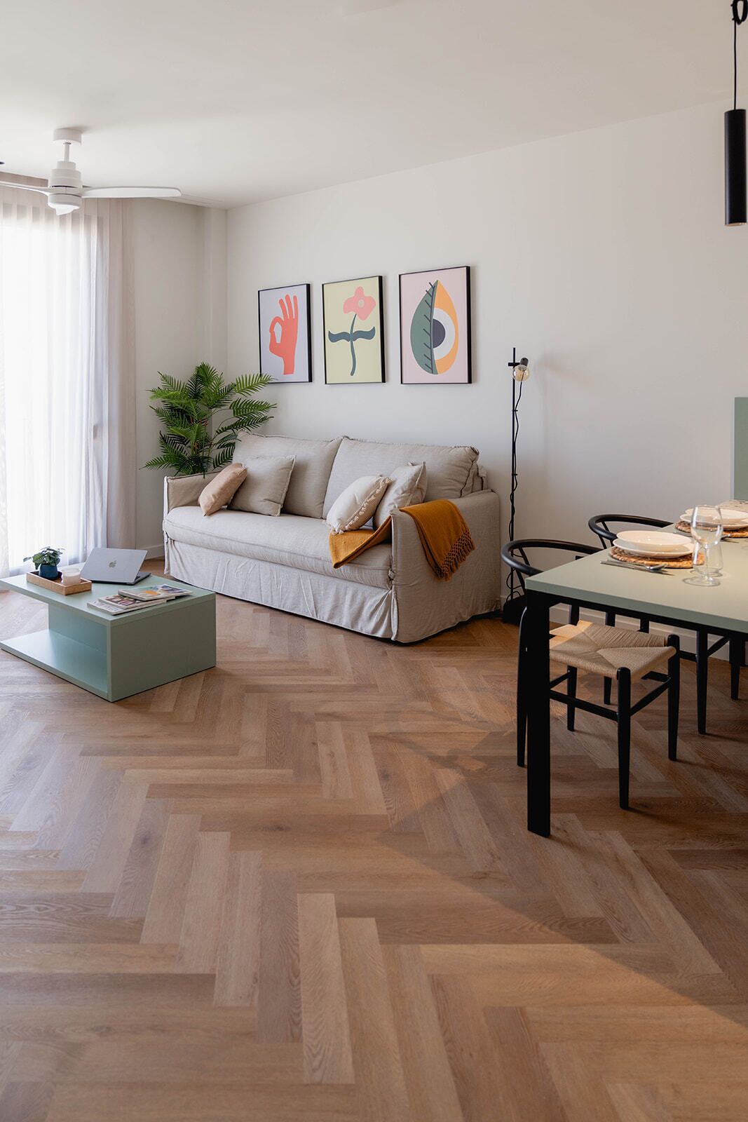 A modern living room with a sofa, coffee table, and dining table.
