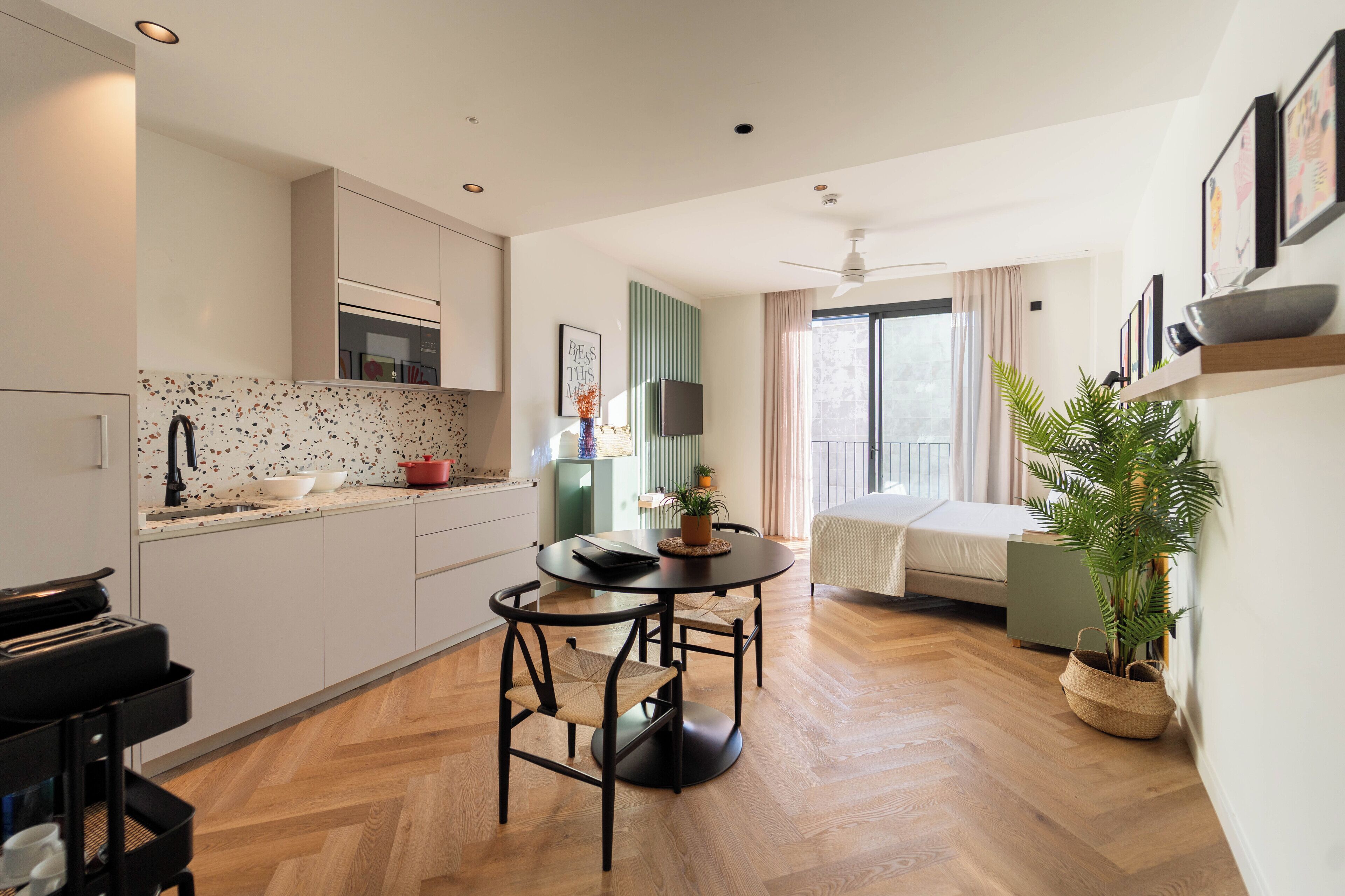 Una cocina moderna con comedor, una cama y un amplio ventanal.