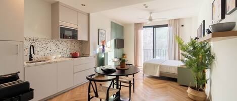 Una cocina moderna con comedor, una cama y un amplio ventanal.