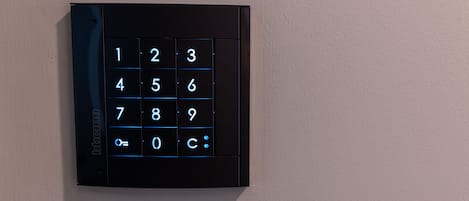 Un teclado numérico negro fijado a la pared.