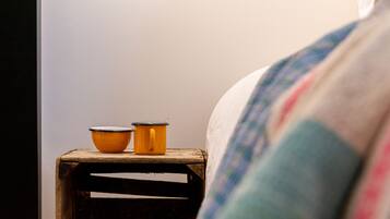 A wooden nightstand with two orange containers and a white wall in the background.