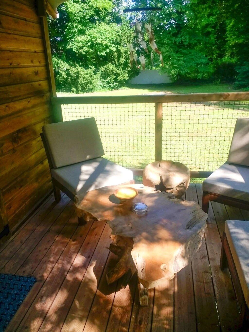 A wooden deck with two chairs and a table.