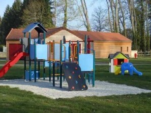 Kids can play on the slide, climbing frames, and playhouse in this outdoor playground.