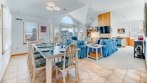 A spacious living area with a dining table, chairs, and a sofa set. - The beautiful beaches of Corolla are just a few feet away at Oasis! (Corolla)