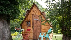 A wooden cabin with a door labeled "Neh M'Phe," a small porch, and two colorful chairs. - ZEcamping 2 étoiles piscine couverte animaux acceptés locatif 6m2 2 pers (Bar-sur-Aube)