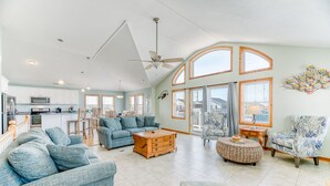 A spacious living room with a high ceiling, a dining area, and a kitchen. - Sun Realty ocean and sound views only 600 ft from semi-private beach access (Nags Head)