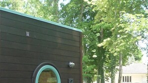 Un télescope installé sur un trépied, à l’extérieur d’un bâtiment moderne doté d’une terrasse en bois.