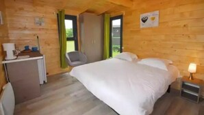 Une chambre de style cabane en bois, avec un lit, un bureau et une chaise.