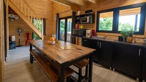 Un intérieur en bois comprenant une cuisine, un coin repas et un escalier.
