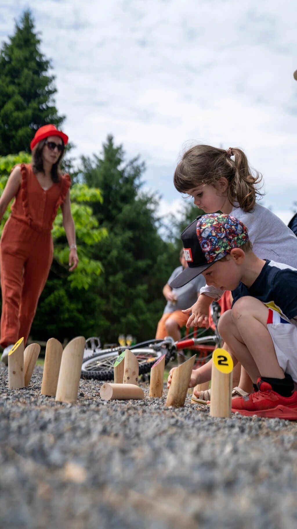 A group of people engaged in an outdoor activity, possibly a race or obstacle course, with numbered markers on the ground.