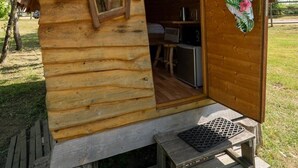 A wooden cabin with a sign reading "Merlin," a window, and a door with a red ornament. - ZEcamping piscine chauffée animaux acceptés sauna cabane BBQ 6m2 (Chassenard)