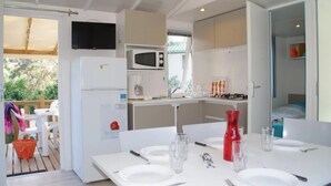 Une cuisine compacte équipée d’un four à micro-ondes, d’un réfrigérateur et d’un coin repas aménagé pour prendre un repas.