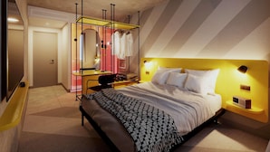 Een moderne hotelkamer met een bed, nachtkastje en een kaptafel met spiegel en kledingrek.