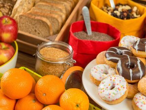 Variedad de alimentos como naranjas, rosquillas y pan.
