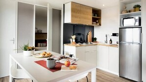 Een moderne keuken met witte kasten, een roestvrijstalen koelkast en een houten aanrecht.