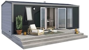 Een modern, compact gebouw met een patio, compleet met een stoel, een tafel en een bloempot.