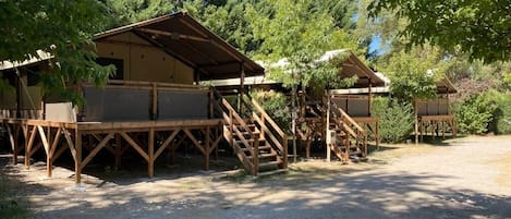 A rustic cabin-style lodging with wooden decks and staircases leading to elevated platforms.
