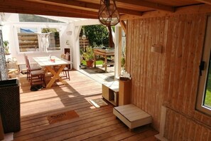 A wooden interior with a dining area, a small table, and a bench.