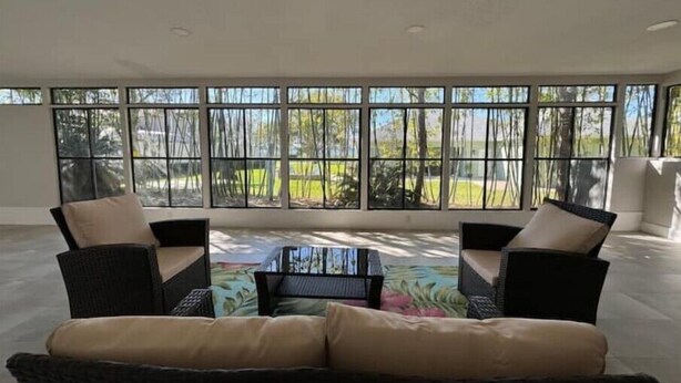 Una habitación amplia con un gran ventanal, un sofá y una mesa de centro.