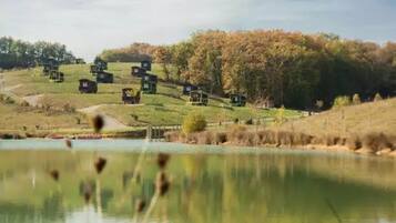 A serene lakeside setting with multiple cabins, a clear sky, and autumn foliage.