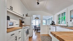 Une cuisine moderne avec des meubles blancs, un plan de travail en bois et un îlot central.