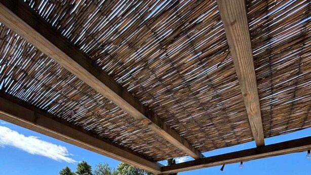 A pool area with wooden deck chairs and a table, surrounded by a wooden pergola. - ZEcamping 3 étoiles piscine chauffée locatif TV clim 34m2 (Roquebrune-sur-Argens)