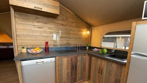 Una cocina compacta con armarios de madera, lavavajillas y pileta.
