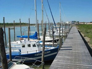 Guests can enjoy a serene waterfront experience with access to a tranquil body of water and moored boats.
