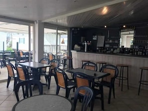 Guests can dine and socialize in this stylish dining area with a bar, featuring comfortable seating and a selection of drinks.