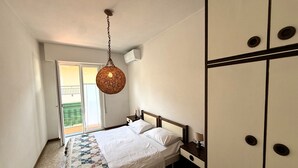 A bedroom with a bed, a hanging light fixture, a nightstand, and a wardrobe. - Casa Liver Pieve balcony town center (Tremosine)
