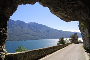 A road leading to a mountainous landscape with a clear view of a lake and mountains.